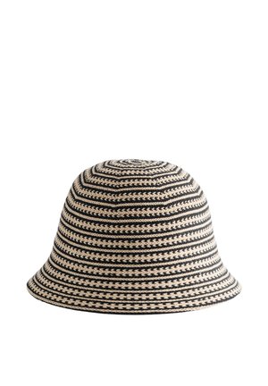 Sombrero tipo bucket tejido, de rayas negras y beige, con copa redondeada y ala inclinada hacia abajo sobre un fondo blanco liso.