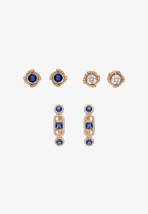 Dwie pary złotych kolczyków na sztyft z okrągłymi niebieskimi i przezroczystymi kamieniami otoczonymi małymi diamentami oraz jedna para złotych kolczyków wiszących z niebieskimi kamieniami.