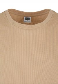 T-shirt beige côtelé à col rond de Urban Classics, taille M, fabriqué au Bangladesh.