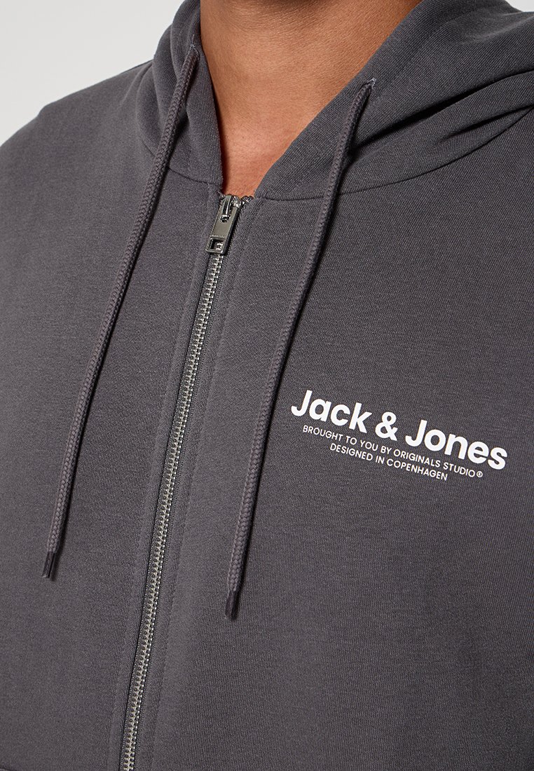 Szara bluza z kapturem zapinana na zamek, wykonana z miękkiego materiału. Posiada sznurek w kapturze oraz białe logo nadrukowane po lewej stronie klatki piersiowej. Srebrny zamek.