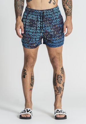 Bañadores en azul y negro con un patrón geométrico que presenta letras. Hechos de tela ligera, con una cintura elástica y cordón ajustable.
