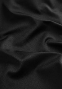 Tissu noir avec une texture lisse et brillante ; drapé pour montrer des plis et des froissements subtils, de couleur uniforme sans motifs ni accents visibles.