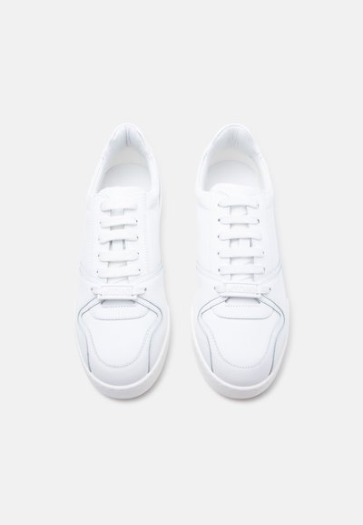 Een paar schone witte leren sneakers met witte veters, ronde neuzen en subtiele stiksel-details, gezien van bovenaf op een lichte achtergrond.