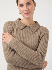 Pulover tricotat bej cu textură tip rețea, având un guler moale, rotunjit și mâneci lungi. Țesătura pare călduroasă și confortabilă.