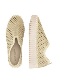 Zapatos slip-on de color beige claro con un patrón de ola texturizado, suela de goma flexible y laterales recortados para mayor transpirabilidad.