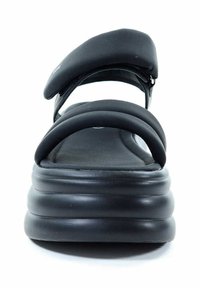 Czarne sandały na platformie z wyściółkowanym, podwójnym paskiem i grubą, teksturowaną podeszwą. Materiał wierzchni jest gładki i elastyczny.