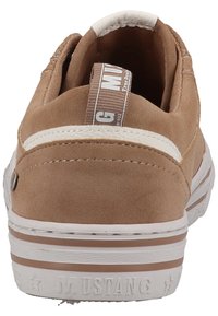 Scarpa slip-on in suede marrone con una striscia di accento bianca, suola in gomma e un dettaglio del logo sul retro. Presenta una tomaia testurizzata e cuciture.
