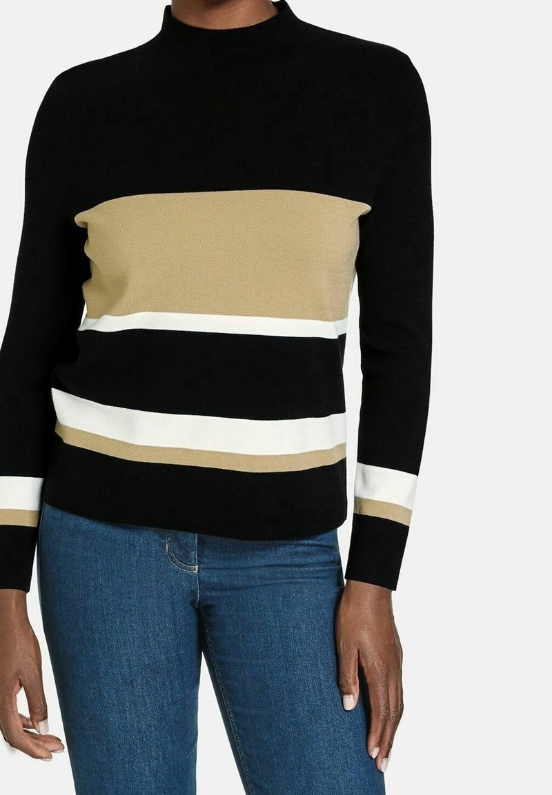 Schwarzer Pullover mit hohem Kragen und horizontalen Streifen in Beige, Weiß und Gold. Weicher Stoff, figurbetonter Schnitt und lange Ärmel.