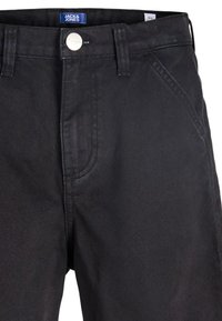 Μαύρο τζιν παντελόνι από denim με κούμπωμα κουμπιού, μπροστινές τσέπες και διακριτικές ραφές. Το ύφασμα έχει ελαφριά γυαλάδα και λεία υφή.