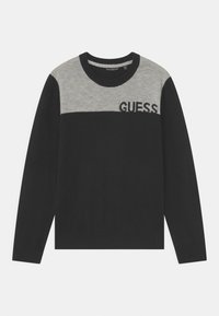 Maglione lavorato a maglia in nero e grigio con scollo rotondo, caratterizzato da un design a blocchi di colore orizzontali e il logo "GUESS" in nero sulla zona del petto.