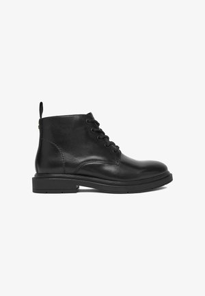 Schwarzer Leder-Stiefelette mit Schnürung vorne, Zuglasche an der Ferse und niedrigem Blockabsatz.