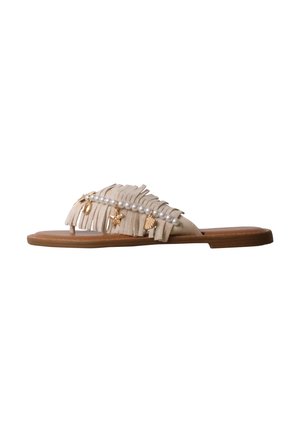 Sandale plate beige avec détails en franges, une rangée de perles blanches et des breloques dorées sur le thème de la mer sur une semelle marron, isolée sur fond blanc.
