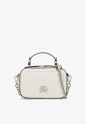 Baltas taisnstūra ādas rokassoma ar augšējo rokturi un sudraba ķēdes siksnu, ar sudraba metāla logo priekšpusē.