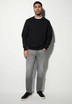 Zwarte sweatshirt, grijze jeans, zwarte sneakers. Eenvoudig ontwerp, katoenen textuur, aansluitende vorm, effen kleuren zonder patronen of zichtbare hardware.