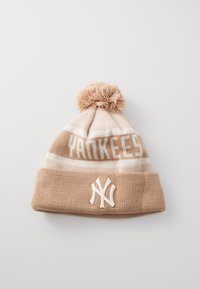 Hnědá pletená čepice s bambulí na vrchu. Obsahuje text "YANKEES" a bílé vyšívané logo, doplněné světlými krémovými pruhy.