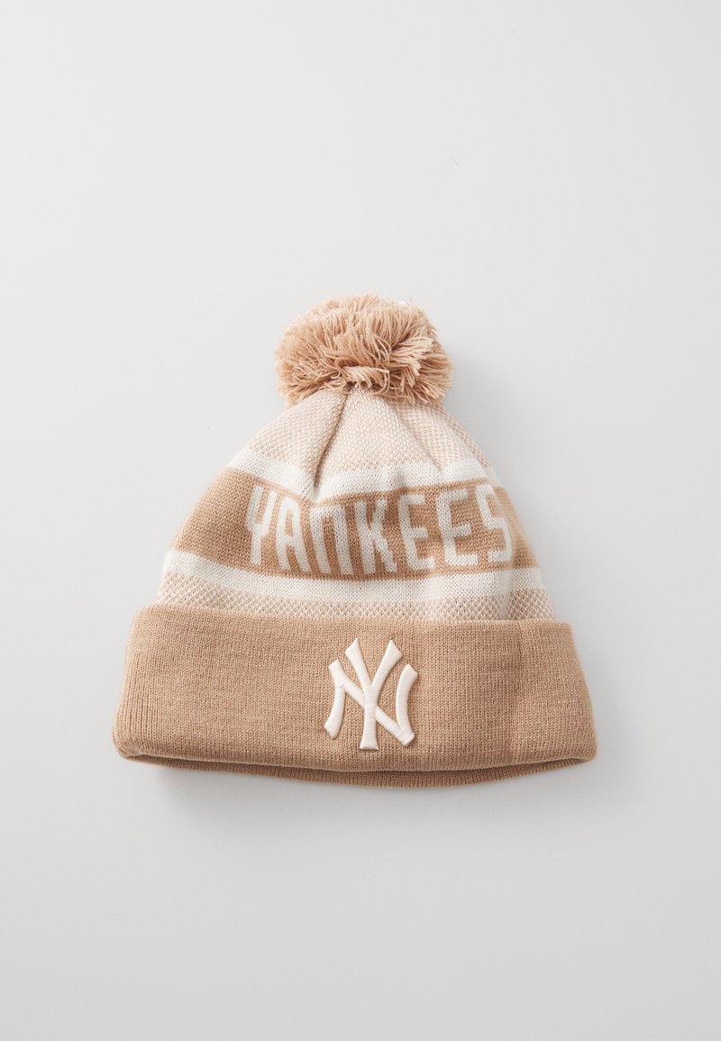 Hnědá pletená čepice s bambulí na vrchu. Obsahuje text "YANKEES" a bílé vyšívané logo, doplněné světlými krémovými pruhy.