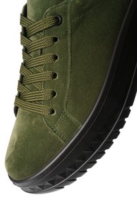 Green suede sneaker with thick black textured sole and matching green laces threaded through metal eyelets.