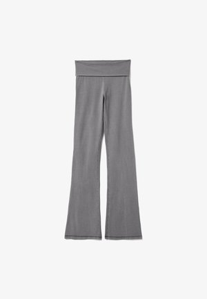 Graue Yogahose mit weitem Umschlagbund und ausgestellt geschnittenem Bein, flach auf weißem Hintergrund gezeigt.