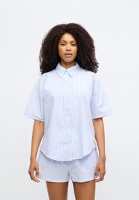 Πουκάμισο με κοντά μανίκια και κουμπιά σε ανοιχτό μπλε χρώμα με λευκές ρίγες, με γιακά spread και απαλό βαμβακερό ύφασμα. Συνδυάζεται με σορτς στο ίδιο μοτίβο.