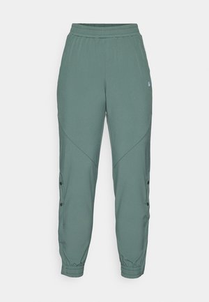 Roheline, kerge jogger stiilis püksid elastse vöökoha, kitsenevate sääreosade, külgnuppude ja kaldu õmblusdetailidega, et luua voolujooneline välimus.