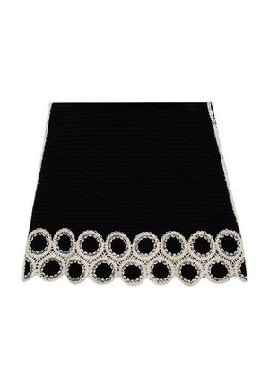 Zwarte gehaakte rok met een decoratieve witte kantafwerking met ronde patronen langs de zoom. Gladde textuur met een gestructureerde vorm.