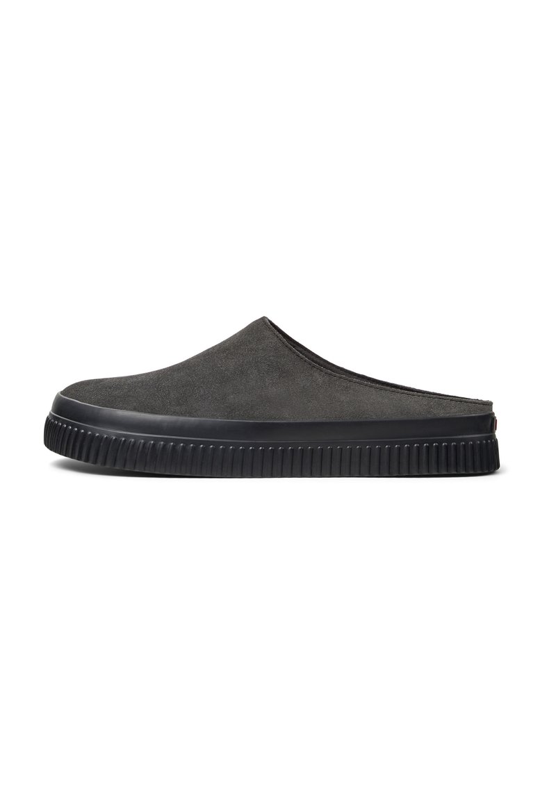Zapatos slip-on de ante gris con punta redondeada, superficie texturizada y suela de goma negra con un patrón estriado.