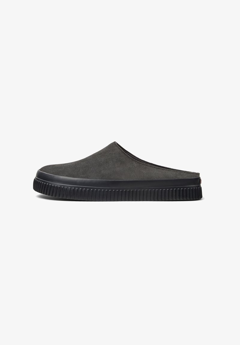 Harmaat mokka-slip-on-kengät, joissa on pyöreä kärki, teksturoitu pinta ja musta kumipohja, jossa on uritettu kuvio.