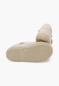 Scarpe slip-on in tela beige con suola testurizzata, dettaglio in juta intrecciata sul tallone e chiusura con strap in Velcro.