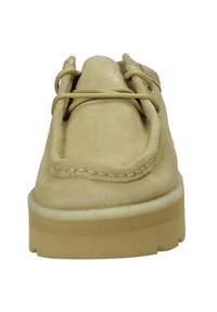 Scarpa in suede beige con punta rotonda, due lacci e suola in gomma leggera. Presenta cuciture lungo il bordo e una superficie texturizzata.