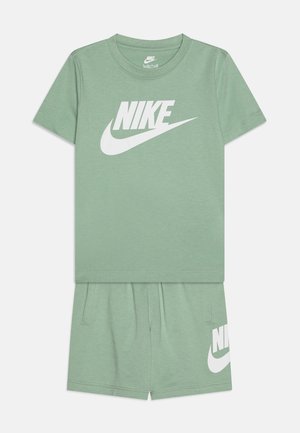 Ανοιχτό πράσινο μπλούζα Nike με κοντά μανίκια και μεγάλο λευκό λογότυπο, σε συνδυασμό με αντίστοιχες βερμούδες που διαθέτουν λεπτομέρεια με λογότυπο και τσέπες.