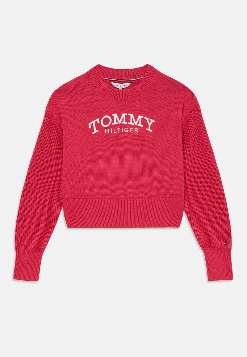 Červený zkrácený svetr s ribkovanou strukturou a kulatým výstřihem. Na přední straně se nachází bílé logo "TOMMY HILFIGER". Má dlouhé rukávy s ribkovanými manžetami.