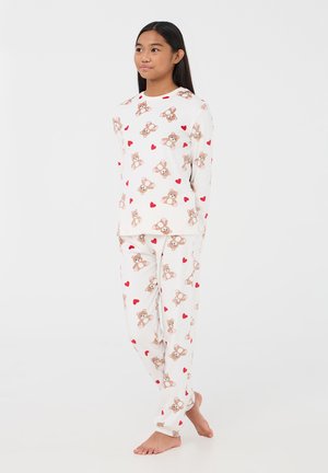 Completo pigiama in cotone con maniche lunghe e pantaloni, caratterizzato da una base bianca e un motivo di orsetti con cuori rossi. Morbido, vestibilità comoda.