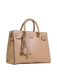 Beige læderhåndtaske med struktureret design, flettede håndtag, hardware i guldton og en dekorativ vedhæng fastgjort på siden.