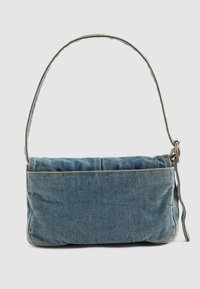 Kleine rechteckige Jeans-Schultertasche mit langem Riemen und Messing-Schnalle, auf einem schlichten hellen Hintergrund präsentiert.