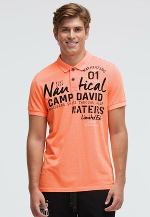 Kurzärmeliges Polohemd aus leuchtend orangefarbener Baumwolle mit schwarzem Aufdruck und zwei schwarzen Knöpfen am Kragen.