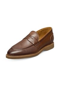 Mocassins en cuir marron avec un design cousu, bout arrondi et une semelle en caoutchouc texturée et basse. Comprend une fente pour une pièce sur le dessus.