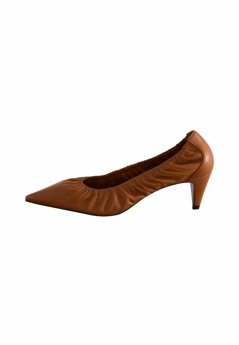Bruna läderpumps med spetsig tå, medelhög klack och samlad textur runt öppningen. Slät yta och subtil lyster.