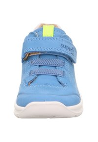 Blaue synthetische Sneaker mit einem Klettverschluss, elastischen Schnürsenkeln, weißer Sohle und einem leuchtend gelben Akzent am Riemen.