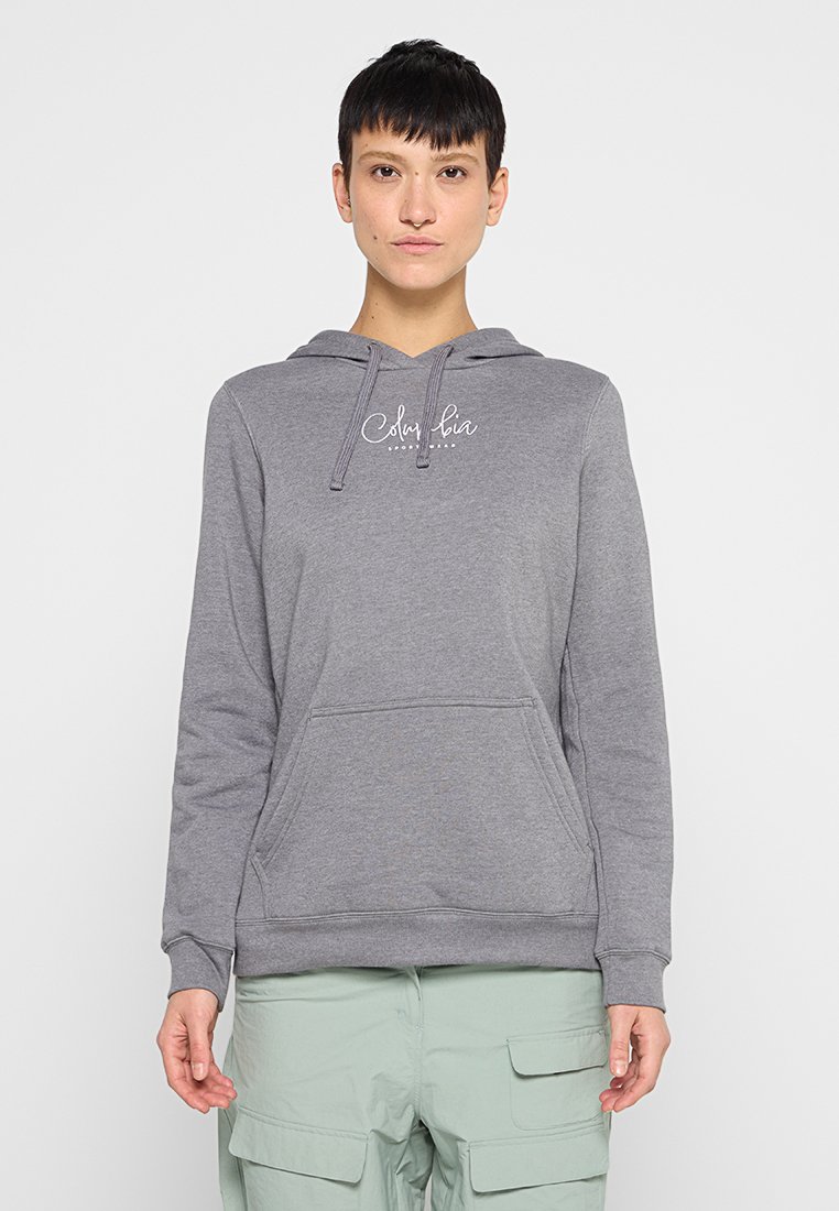 Sudadera gris con un bolsillo frontal y capucha con cordones. Presenta el logo "Columbia" en texto blanco en el pecho. El material parece suave y con textura.