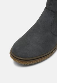 Hallide hall boots, mille juurega, tekstureeritud kummitald ja minimaalsed õmblusaktsendid vastupidavuse tagamiseks.