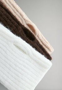 Úložné tašky z vlnenej zmesi v bielej, hnedej a ružovej farbe s rebrovanou textúrou a hornými rúčkami pre jednoduché prenášanie.