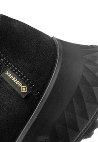 Schwarzer Wildlederschuh mit einer verstärkten Gummisohle mit geometrischem Muster, einer genähten Naht und einem Gore-Tex-Tag für Wasserdichtigkeit.