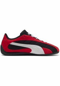 Zapatillas rojas y negras con una parte superior texturizada, que presentan un acento de raya blanca, un diseño de perfil bajo y cordones para un ajuste seguro.