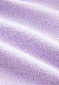 Close-up of soft, textured fabric in light purple with gentle folds showing a plush, terry cloth surface.