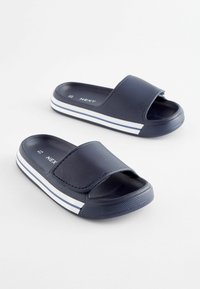Marinefarbene Slipper aus glattem, synthetischem Material, mit einem breiten Riemen und weißen Streifenakzenten auf der Sohle. Strukturierte Außensohle für besseren Halt.