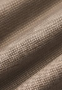 Beżowa tkanina o fakturze z wzorem tkanym, prezentująca gładką powierzchnię i subtelny połysk, odpowiednia do różnych zastosowań.