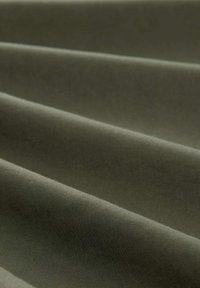 Gewebter Stoff in Olivgrün, mit glatter, leicht strukturierter Oberfläche, horizontalen Falten und durchgängig einheitlicher Farbe.