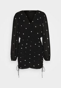 Svart, strukturerad klänning med långa ärmar, V-hals, rynkad midja och silverfärgade prickar. Har justerbara snören i nederkanten för anpassning.