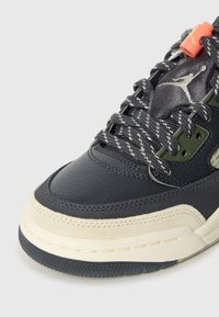 Temno modra usnjena superga z teksturirano površino, okrepljenim prstnim delom, bež srednjim delom podplata in vzorčastimi vezalkami. Vezalke imajo oranžen poudarek.