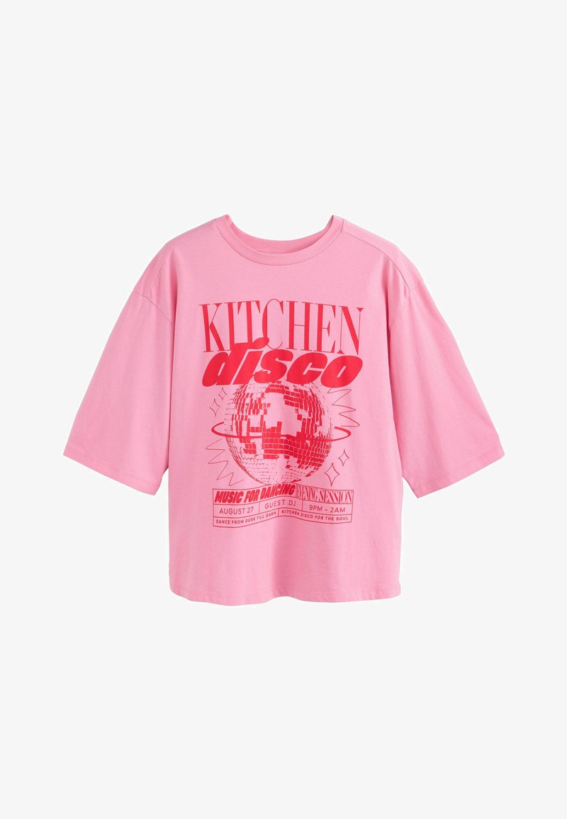 T-shirt rose oversize avec texte rouge "KITCHEN disco" et un graphisme de boule à facettes, promouvant un événement dansant de 21h à 2h le 27 août.